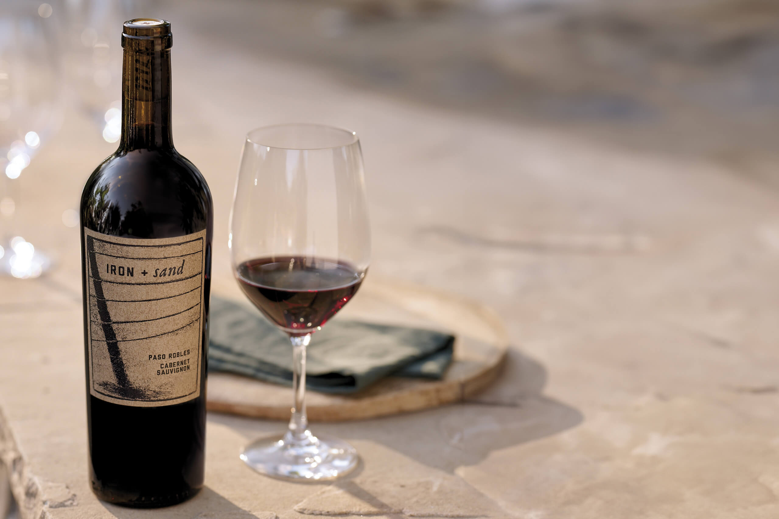 Iron + Sand Wines glass of wine and wine bottle scene